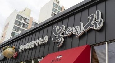 빨간 차양과 «복터진집» 간판이 달린 낮의 가게 앞